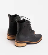 Bota corta acordonada de cuero color marrón, con puntera brogue, caña media y taco bajo de madera.