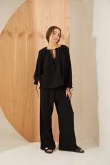 Pantalón negro de corte amplio y relajado, hecho 100% en algodón, con cintura elástica.