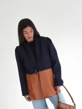 Blazer azul marino corto de lana con cuello solapa y mangas abullonadas.