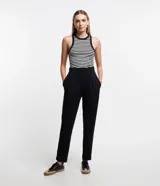 Pantalón zanahoria negro de punto roma, con cintura lisa, bolsillos laterales y pliegues delanteros.