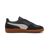 Zapatillas bajas de cuero negro con detalles en blanco y suela de goma marrón.