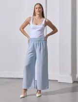 Pantalón largo de poliéster color beige con rayas verticales, pretina ancha elastizada en punto smock y pierna ancha.