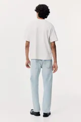 Pantalón de jean celeste de corte recto y tiro medio, con cinco bolsillos y cierre con botón.