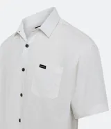 Camisa blanca de corte relajado, confeccionada en cáñamo y algodón. Tiene cuello inglés, manga corta, abotonadura frontal, bolsillo en el pecho y textura texturizada.