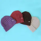 Gorro de lana color marrón, con diseño de canalé y etiqueta discreta.