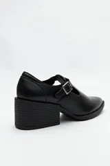Zapato negro con diseño tipo T-bar, tira con hebilla lateral y taco ancho de 6cm.