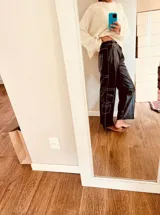 Pantalón cargo de cuero ovino negro con costuras blancas en contraste y corte suelto.