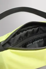 Riñonera deportiva color amarillo flúor, con cierre de cremallera termosellada, correa ajustable con hebilla de liberación rápida y tejido transpirable en la parte trasera.