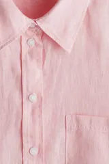 Camisa rosa de lino liviano, de corte recto, con cuello clásico, botones frontales, manga larga con puños abotonados, canesú en la espalda, bolsillo de parche en el pecho y bajo redondeado.