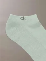 Pack de tres pares de medias invisibles Calvin Klein, en color blanco, gris y verde. Cada media tiene el logo 'ck' en el tobillo y el nombre 'Calvin Klein' en la planta del pie.