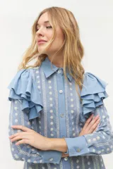 Camisa de manga larga con cuerpo y mangas de algodón bordado, adornada con volantes en los hombros.