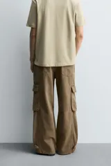 Pantalón cargo relaxed fit confeccionado en denim color marrón. Cuenta con bolsillos frontales, traseros de plastrón y multifunción en perneras. Tiene efecto lavado, bajo ajustable con trabilla y cierre frontal con cremallera y botón.