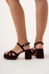 Sandalia de fiesta color vino con triple tira delantera entrelazada y pulsera con hebilla. Plataforma delantera de 2,5 cm y taco de 8 cm.