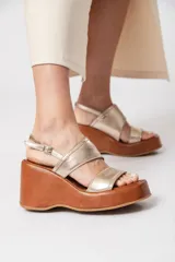 Sandalia con plataforma forrada y taco corrido, doble tira y agarre con hebilla. Plataforma de goma microporosa forrada (eva).