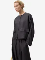 Sobrecamisa gris de lino y viscosa con cuello caja, manga japonesa, botonadura frontal y bolsillos de tapeta con botón.