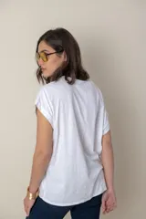 Blusa italiana color celeste con bordado de plumas al tono en el frente, confeccionada en lino y algodón.