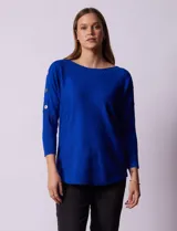Buzo azul tejido en hilado fino, marca Cable & Gauge. Escote redondo con calados. Manga ¾, modelo dolman. Mangas con aplique de botones.