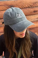 Gorra de gabardina gris con visera curva y logo bordado en el frente.
