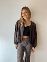 Campera marrón de cuero sintético, corte holgado, con cierre frontal y mangas largas con puños elásticos.