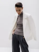 Blazer blanco de corte oversize, con cuello de solapa y cierre con botones.