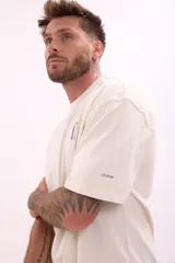 Remera color crudo de corte holgado con estampado pequeño en el frente.