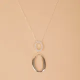 Conjunto de plata 925 con circonias, compuesto por aros colgantes ovalados y collar con dije doble ovalado.