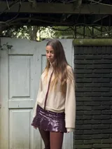 Pollera corta con volado en el ruedo, confeccionada en tela con lentejuelas doradas.