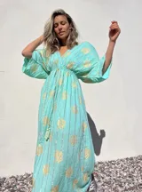 Vestido túnica largo color verde agua con estampado dorado, escote en V y mangas anchas.