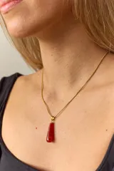 Collar dorado con cadena fina y dije colgante en forma de lágrima de piedra natural azul con vetas blancas.