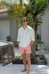 Short de baño color coral con estampado de hojas en tonos más claros.
