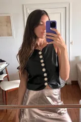 Chaleco negro de cuero con botones de strass.