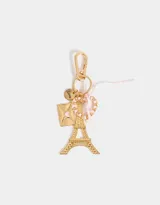 Llavero dorado con dije de la Torre Eiffel, sobre dorado con corazón rosa, dije redondo con la palabra "Love" y cinta de raso rosa.