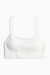 Bralette blanco de breteles finos regulables y bajo ancho acanalado. Copas forradas con relleno extraíble.
