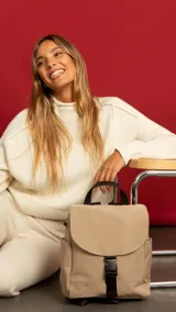 Mochila color beige de nylon con tapa y broche. Incluye bolsillos interiores, bolsillos laterales de fácil acceso, correas regulables y bolsillo en la espalda.