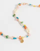 Collar corto de hilo color crudo con cuentas de colores, dijes de caracoles y dije de espiral dorado.