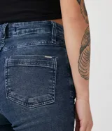 Pantalón skinny de jeans azul oscuro con cintura alta, trabillas, bolsillos y rotos en las rodillas.