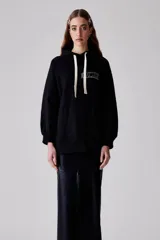 Buzo negro con capucha, confeccionado en algodón Pima, de fit recto y sisa raglán. Presenta un bordado con la palabra "Amore" en el pecho.