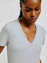 Remera gris de corte clásico, con cuello en V y mangas cortas.