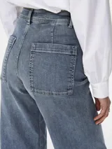 Jean ancho cropped de tiro alto en denim azul medio lavado, con grandes bolsillos utilitarios cuadrados en la parte trasera.