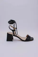 Sandalias rojas de cuero con tiras finas para atar al tobillo y tacón cuadrado.