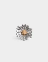 Anillo plateado con forma de margarita y centro dorado.