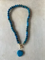 Collar de cuentas de colores con dije de corazón.