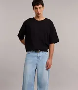 Pantalón de jeans celeste con textura, corte super baggy, cintura con trabillas, cierre tradicional y bolsillos.