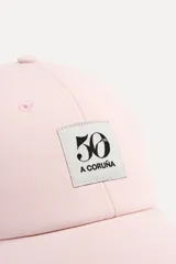 Gorra rosa de algodón con visera y parche bordado con el número 50 y la leyenda "A Coruña".