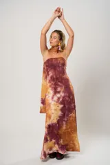 Vestido largo marrón con estampado batik, escote recto, tajo lateral y lazo para atar al cuello.
