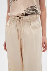Pantalón de jean color beige, de tiro alto, corte palazzo y estilo paper bag.