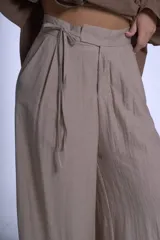 Pantalón de vestir color beige, de corte sastrero con tablas frontales y cintura con lazo.