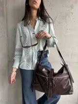 Camisa celeste con bordado inglés, cuello mao y mangas largas abullonadas con puños elásticos.