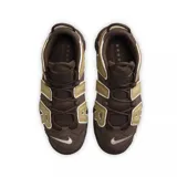 Zapatillas Nike Air More Uptempo '96 color marrón chocolate con detalles en beige y suela a tono. Presentan la palabra "AIR" en letras grandes en los laterales con borde blanco y logo de Nike en rojo en el talón y la puntera.