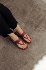 Sandalias marrones de cuero con tiras, microtachas doradas y hebilla lateral.
